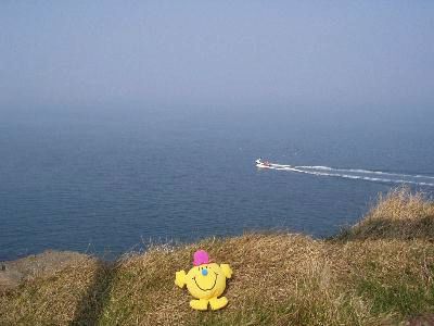 Sat on the clifftop boat in background