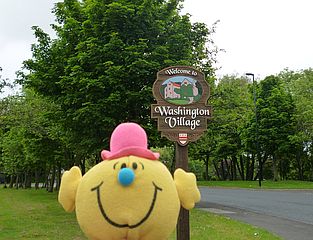 Mr M in front of village sign